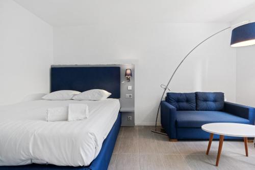 1 dormitorio con 1 cama y 1 sofá azul en Sallaz Residence by Homenhancement, en Lausana