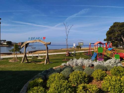 um parque com parque infantil e escorrega em Mobile homes Paun em Privlaka