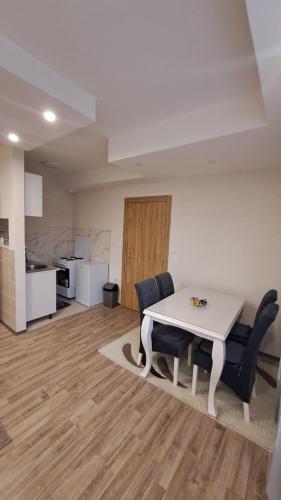 a room with a table and chairs and a kitchen at Apartman Zirojević in Lukavica