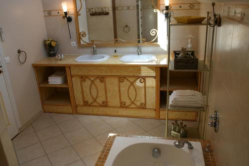 a bathroom with two sinks and a large mirror at La Closerie des Sacres in Lavannes