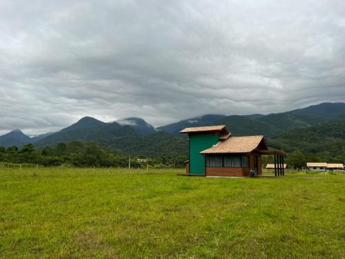 a smallshed in a field with mountains in the background at Morada da Paz in Aguas Mornas