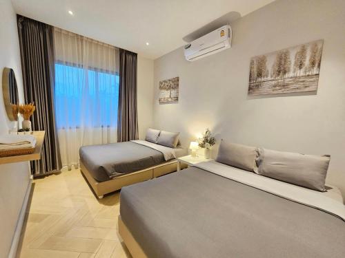 een hotelkamer met 2 bedden en een raam bij 22Pool villa Hua-Hin in Hua Hin