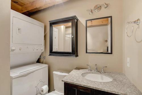 een badkamer met een wastafel, een toilet en een spiegel bij Intimate Apartment with Scenic Views in Baie-Saint-Paul