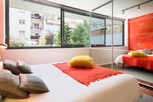 1 dormitorio con cama y ventana grande en Barcino Inversions - Modern Duplex with Private Garden and Swimming Pool, en Barcelona