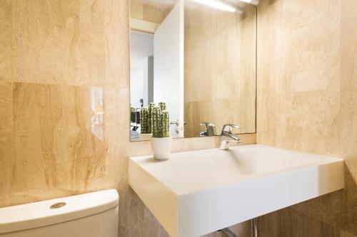 y baño con lavabo blanco y aseo. en Barcino Inversions - Modern Duplex with Private Garden and Swimming Pool, en Barcelona