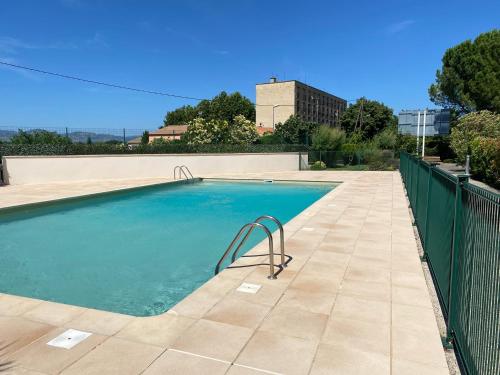 une piscine entourée d'une clôture dans l'établissement les Jardins du Ventoux, à Carpentras