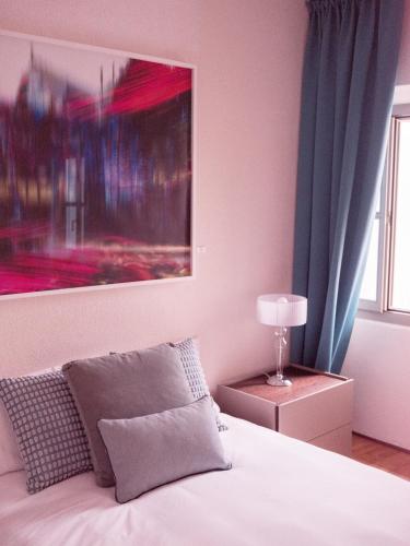 a bedroom with a bed with a painting on the wall at B&B CCAA Ascona in Ascona