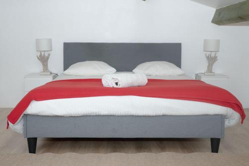 a bed with a red blanket and white pillows at INZO in Montpellier