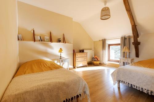 a bedroom with two beds and a window at Gîte à la campagne, 30 min des plages du Morbihan in Pluvigner