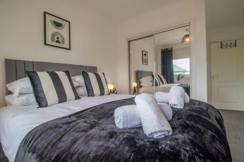 a bedroom with a large bed with towels on it at Park View-modern 2 bed apartment in Motherwell