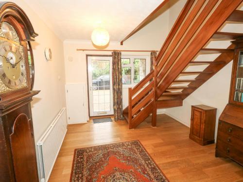 a living room with stairs and a grandfather clock at Glyde House in Dorchester