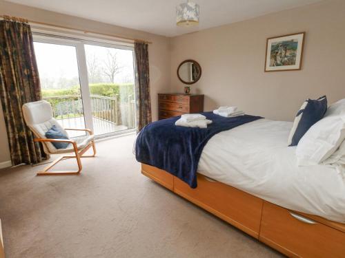 een slaapkamer met een bed, een stoel en een raam bij Glyde House in Dorchester