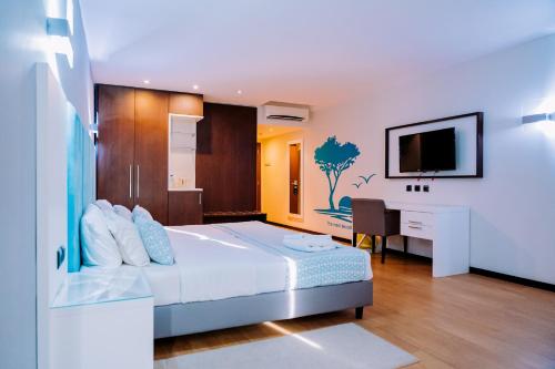 a bedroom with a bed and a desk and a television at Beira Terrace Hotel in Beira