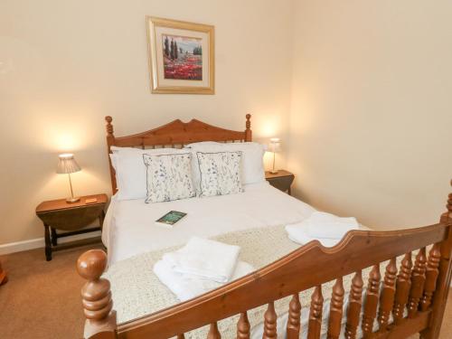 a bedroom with a wooden bed with white sheets and pillows at Glyde House in Dorchester