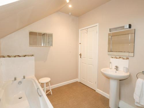 a white bathroom with a sink and a tub and a toilet at Glyde House in Dorchester