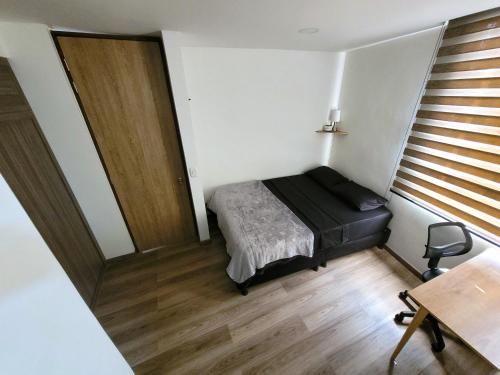 - une petite chambre avec un lit et un bureau dans l'établissement Exclusive Private Brand New-Room, à Bogotá