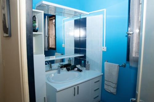 a blue bathroom with a sink and a mirror at INZO in Montpellier