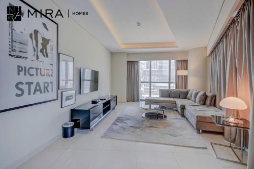 sala de estar con sofá y TV en Mira Holiday Homes - Fully furnished 1 bedroom in Paramount en Dubái