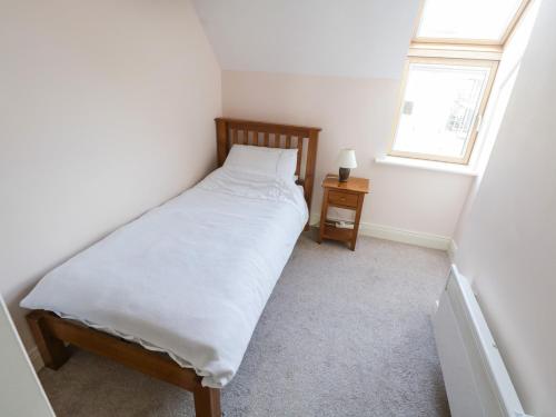 a small bedroom with a bed and a window at Sea Breeze Holiday Home in Enniscrone