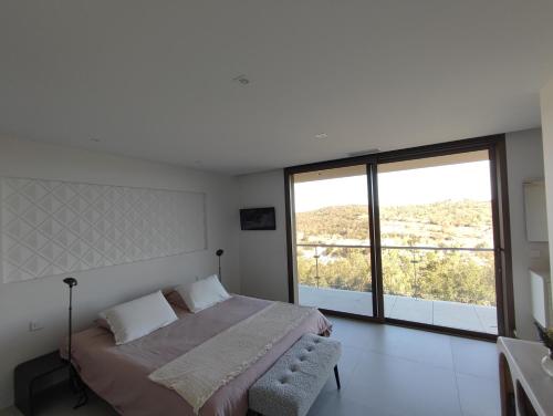 a bedroom with a bed and a large window at La sentinelle du Vallespir, Spa Sauna in Vivès