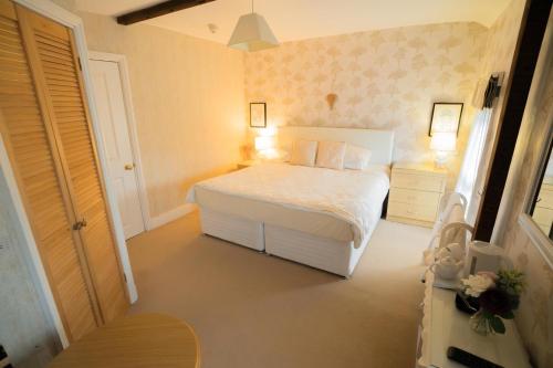 a bedroom with a white bed and two night stands at Maison Dieu Guest House in Dover