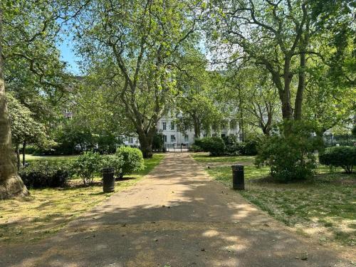 a path in front of a white house with trees at Holborn Apartments in London