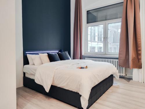 o Loft Studio I 50qm I zentral & ruhig I Messe HBF nah في إيسن: غرفة نوم بسرير مع جدار ازرق
