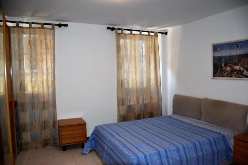 um quarto com uma cama e duas janelas com cortinas em Casa Marina - Holiday Rental em Garda