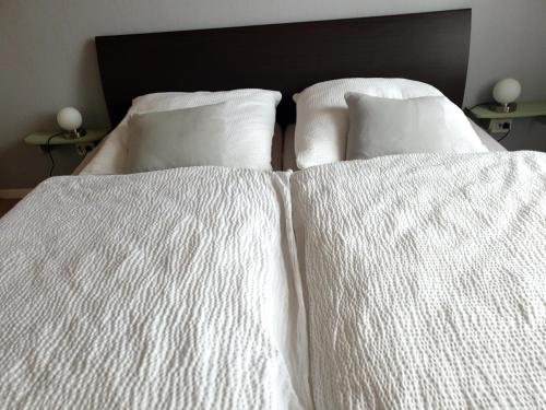 two beds with white sheets and pillows at Das Düsselapartment in Haan