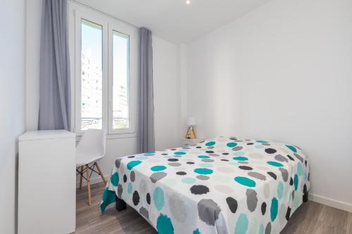 - une chambre avec un lit doté d'une couverture en point de polka dans l'établissement appartement 1er étage, à Antibes