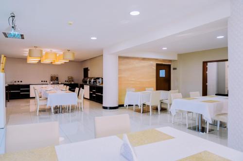a dining room with white tables and white chairs at Beira Terrace Hotel in Beira