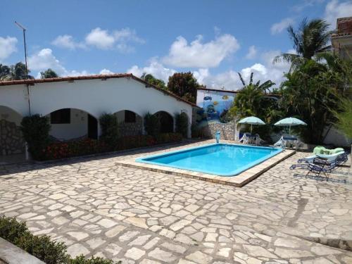 a swimming pool in front of a house at Pousada dos Arcos e Condomínio in Conde