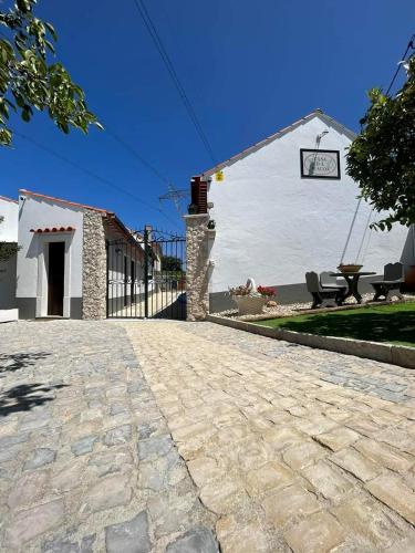 a stone driveway in front of a white building at Casa da Alagoa in Batalha