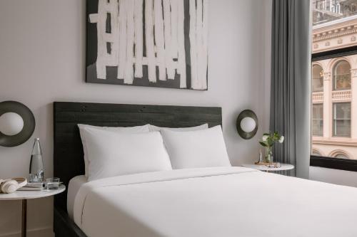 a bedroom with a large white bed and a window at Sonder Duane Street in New York