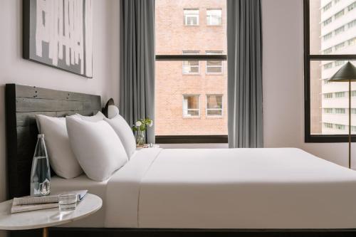 a bedroom with a large white bed and a window at Sonder Duane Street in New York