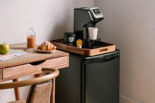 a coffee maker on top of a refrigerator next to a table at Sonder Duane Street in New York