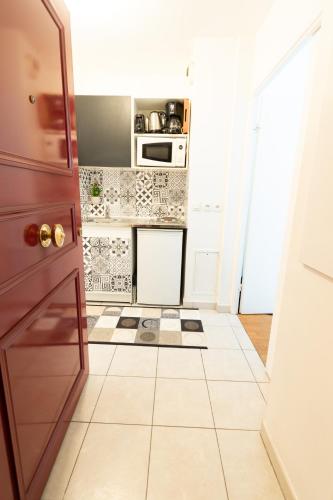 a kitchen with a white tiled floor and a stove at Appartement chic avec parking Paris in Gentilly