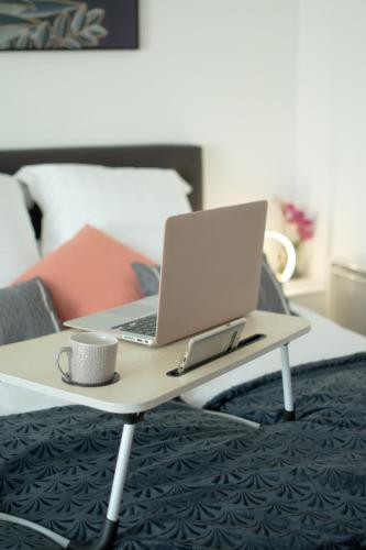 a laptop computer sitting on a coffee table in a bedroom at Appartement chic avec parking Paris in Gentilly