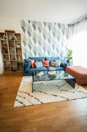 a living room with a blue couch and a table at Appartement chic avec parking Paris in Gentilly
