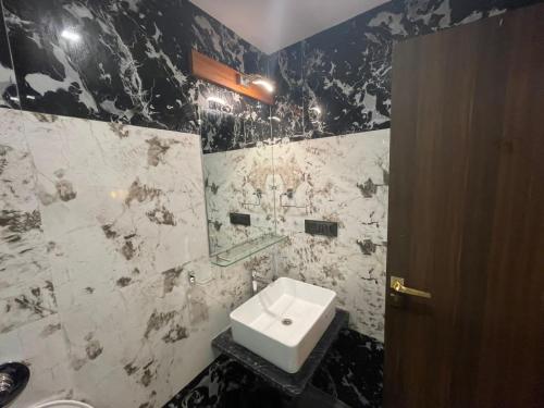 - une salle de bains en noir et blanc avec lavabo et miroir dans l'établissement Sahyadri Stud Farm & Resort, à Mahabaleshwar