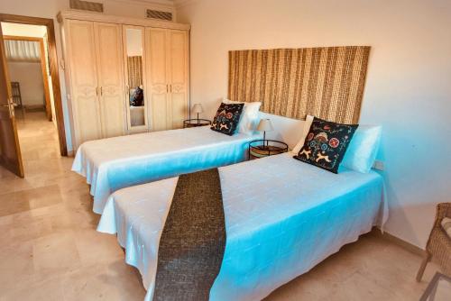 La Playa de TauroにあるM&F Golf Views. Walk to Beachのブルーシーツ付きの客室内のベッド2台