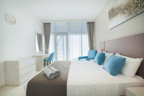 a bedroom with a large bed with blue pillows at Modern 1 bedroom at Palm Jumeirah in Dubai