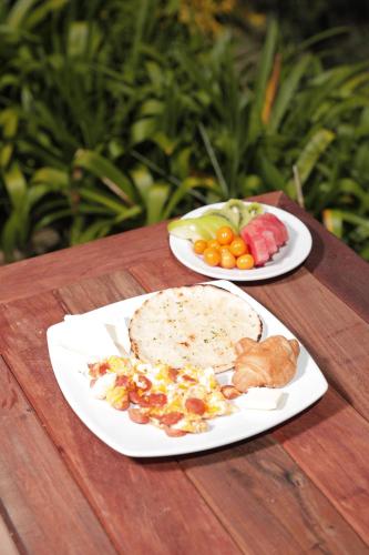 dwie talerze jedzenia na drewnianym stole w obiekcie Alma Hotel Campestre w mieście Santa Elena