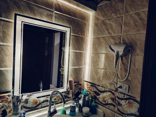 een badkamer met een wastafel met een spiegel en een wastafel bij شقة فندقية بحر مباشر in Alexandrië