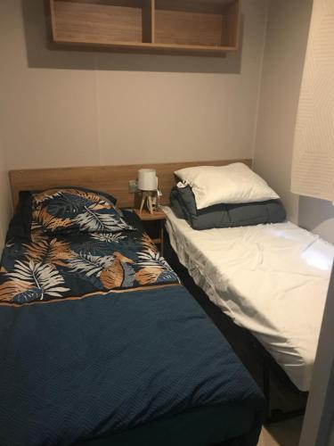 two beds sitting next to each other in a room at Mobil home Aventura 6-8 personnes tout confort in Saint-Brevin-les-Pins