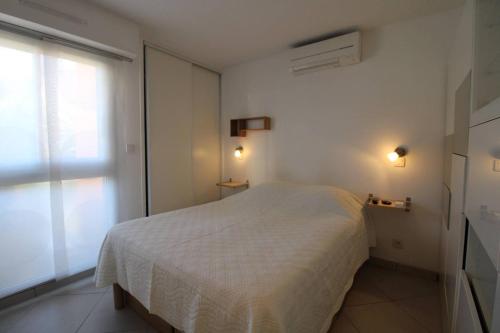 Ένα ή περισσότερα κρεβάτια σε δωμάτιο στο EDENCAU Appartement pour 4 personnes climatisé proche de la mer avec piscine commune au Pradet