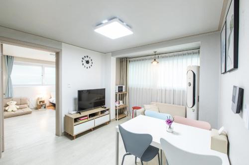 a living room with a white table and a living room at Laon House Yeonnam in Seoul