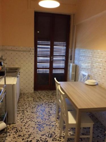 uma cozinha com uma mesa e cadeiras e uma porta em CasaGiulia2Apartament em Pisa