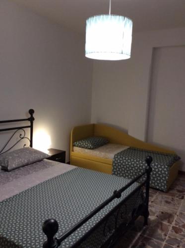 1 dormitorio con 2 camas y lámpara de araña en CasaGiulia2Apartament, en Pisa