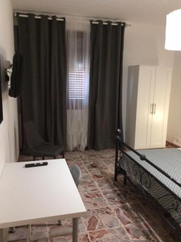 CasaGiulia2Apartament في بيزا: غرفة بسرير وطاولة في غرفة